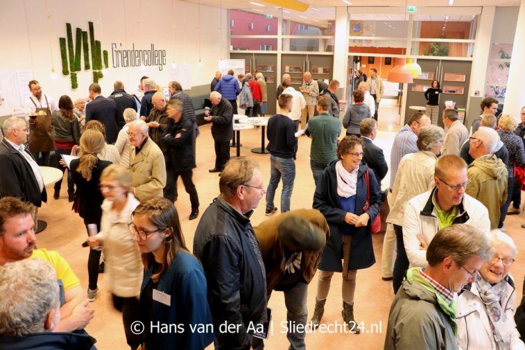 Vóór binnenkomst werden de bezoekers via een introductiefilmpje op een groot TV-scherm ‘begroet’ door wethouder van Milieu en Duurzaamheid Ton Spek (CDA), die tevens in de zaal aanwezig was. Zoals op de foto te zien is, was de opkomst groot. (Foto Hans van der Aa / Sliedrecht24) 